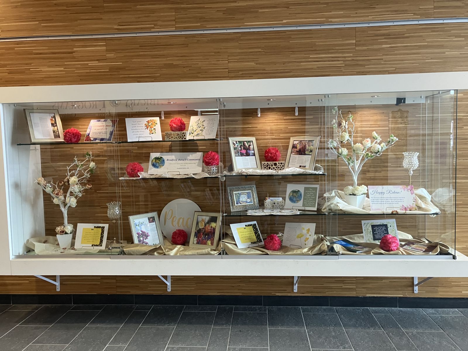 Photo of the main floor display case, filled with the display curated by the Bradford Baha'i Community