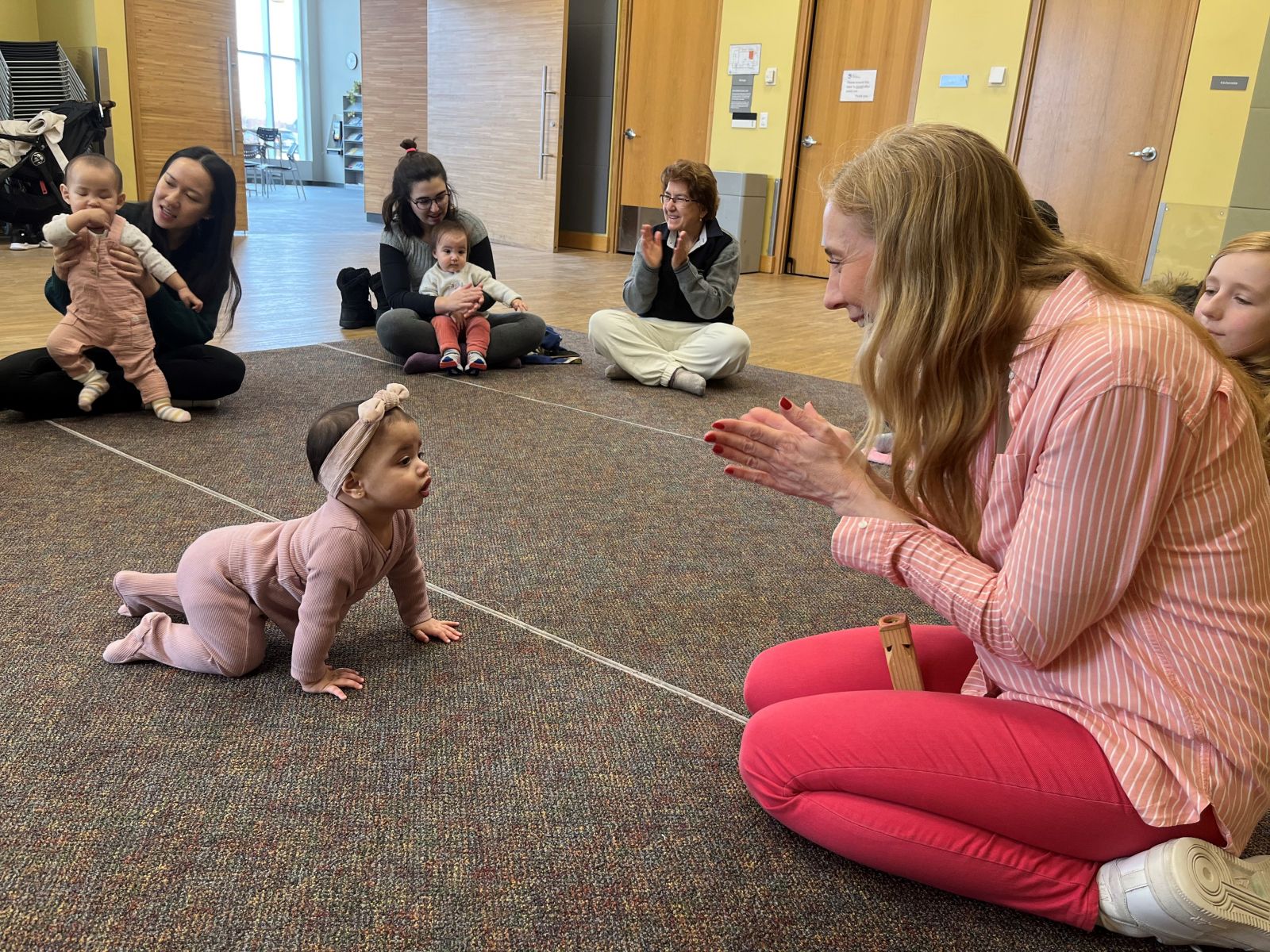 Andrea in the Zima Room with babies doing Storytime