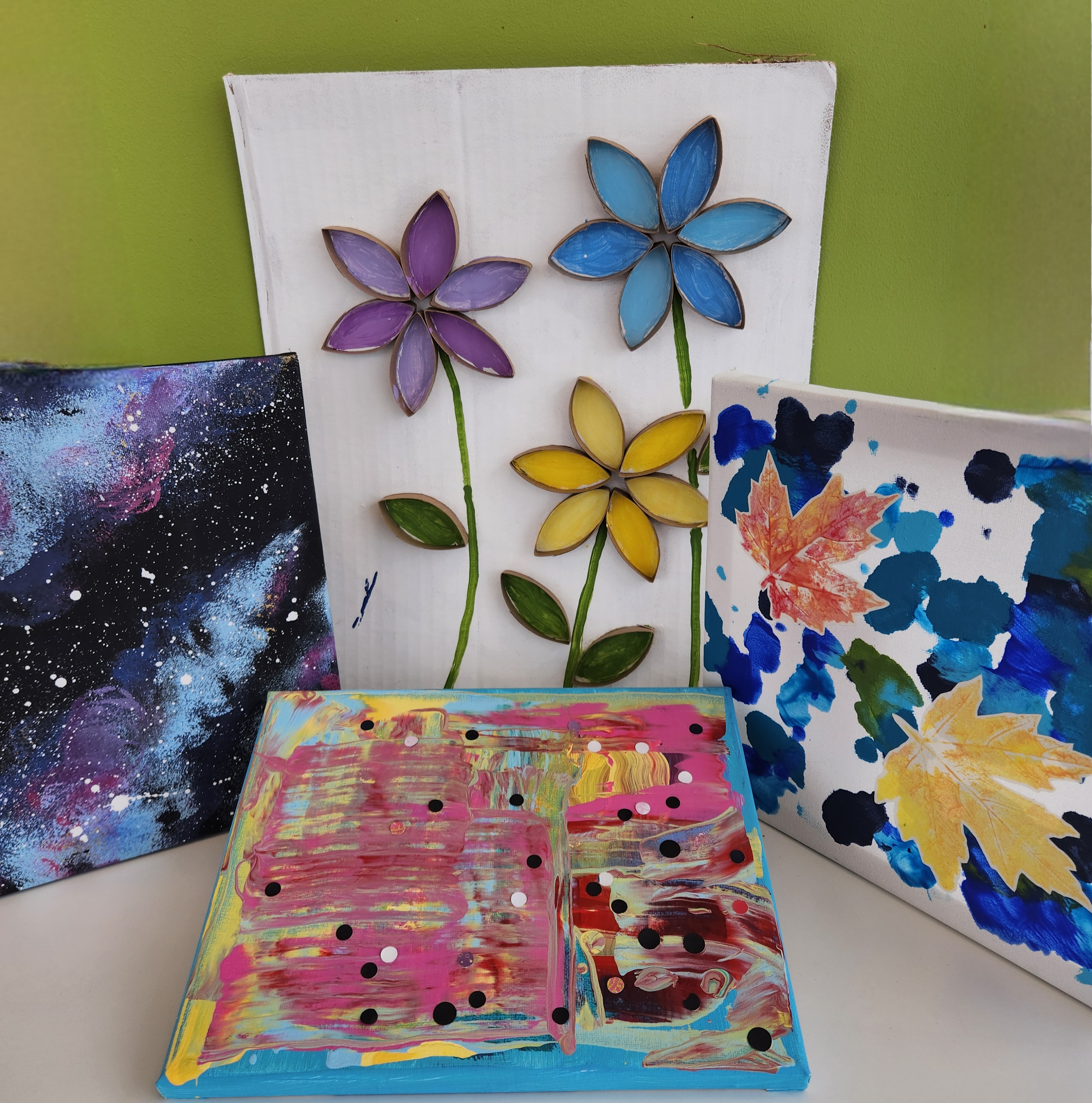 A child with dark hair drawing a picture of space, while stars and planets float above their head.