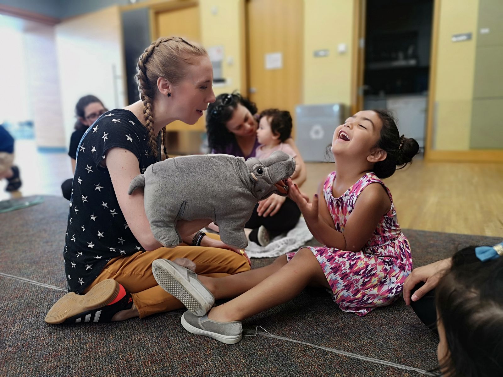 Andrea shows a puppet to a laughing girl.